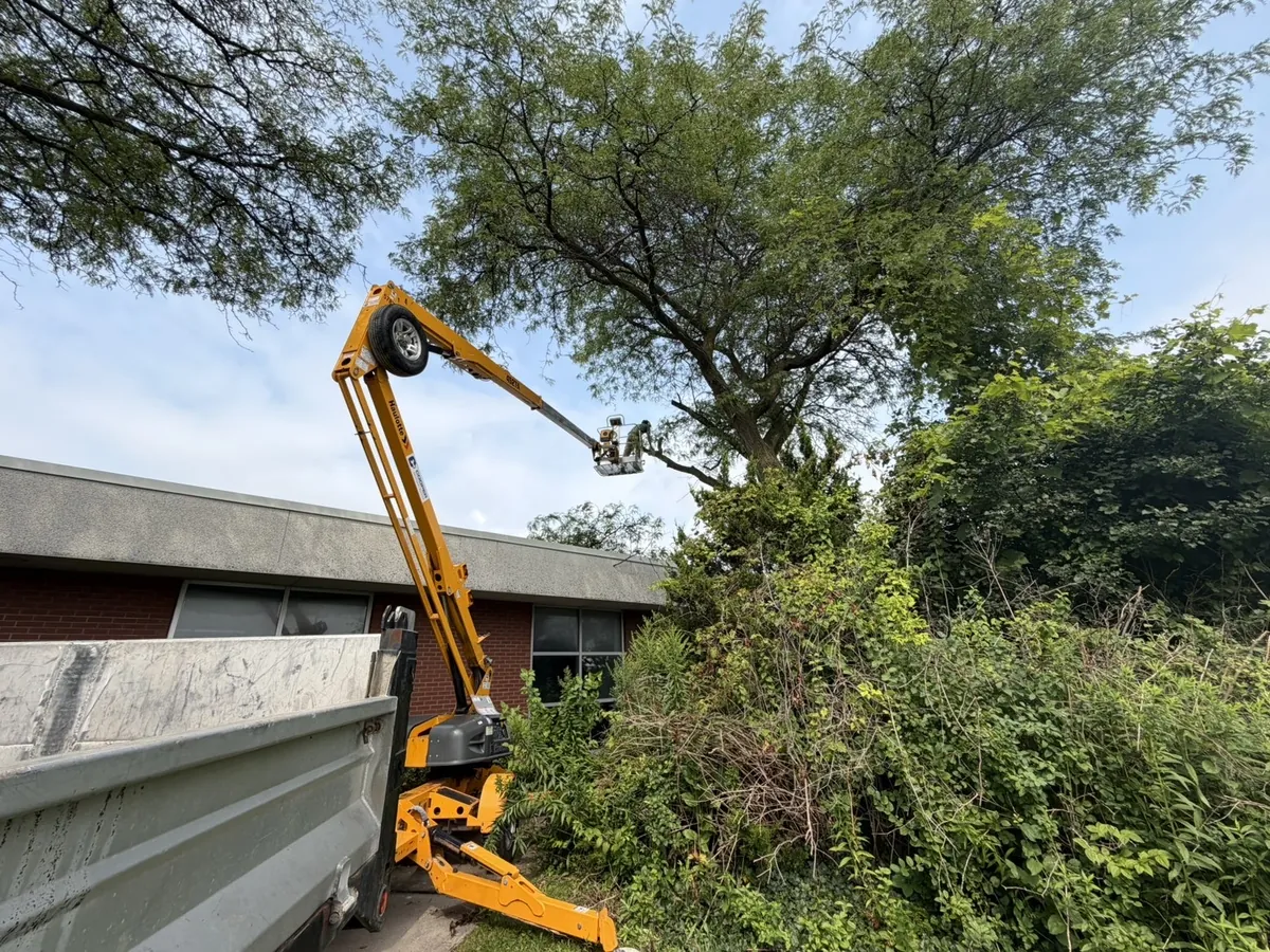 Bucket lift working over a building roofline