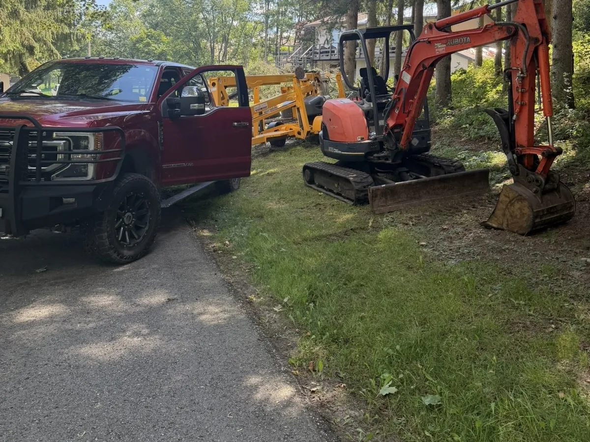 TNT Tree Service truck and excavator on a rural lot